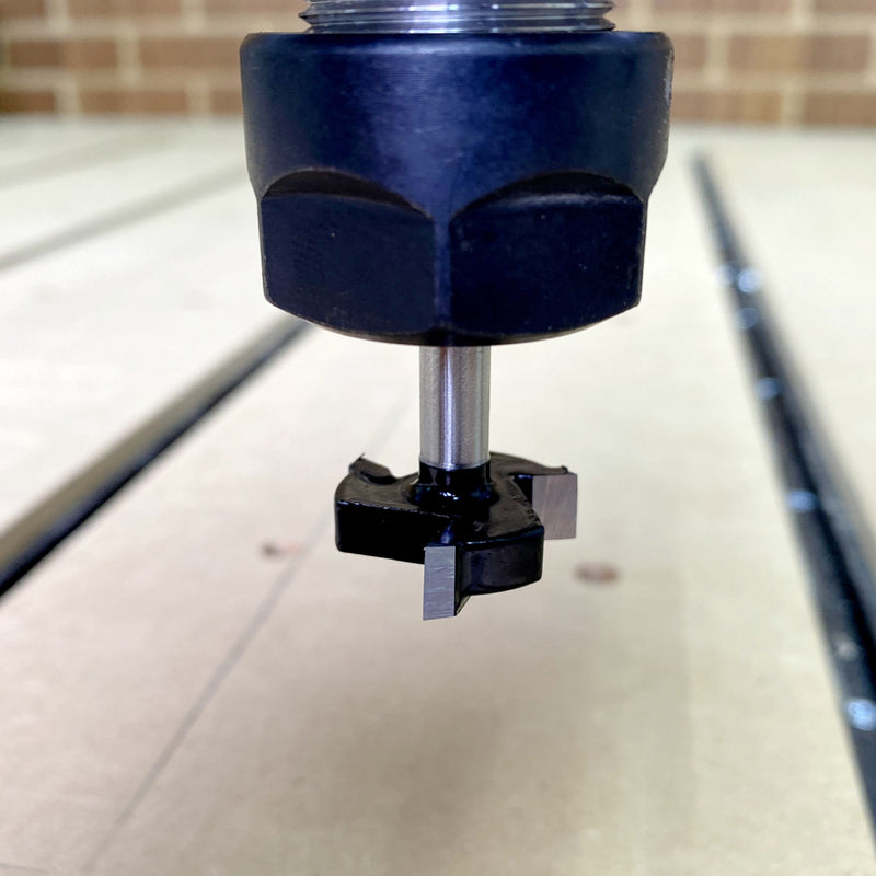 Flycut bit attached to the cnc shown close up with a board underneath 